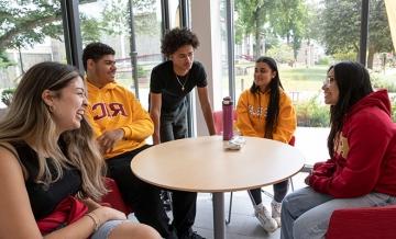 Students talking happily around a table